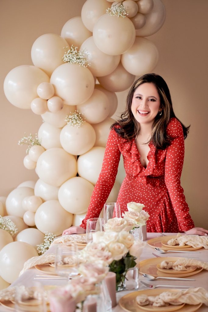 Elly of Pastelly styling a table beside a cream balloon garland